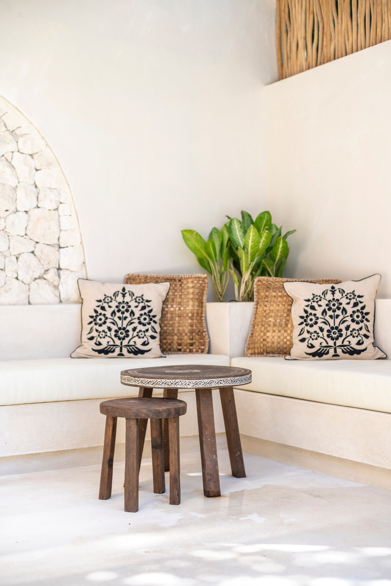 A shaded seating nook at Santika Villas, with block printed cushions and a low wooden table